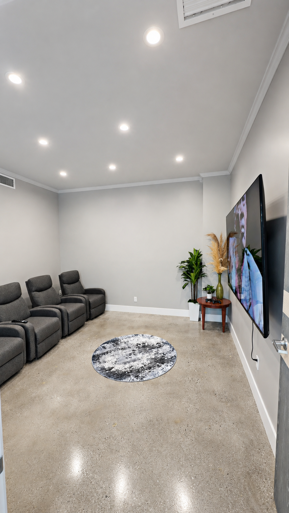Nova Vitae movie room with reclining chairs and a large television